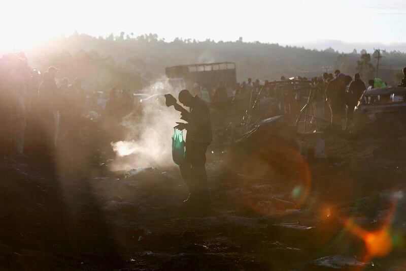 A man walks in the smoke as they assess the wreckages of cars burnt after a fireball from an tanker engulfed several vehicles and killed several people, near the Rift Valley town of Naivasha, west of Kenya’s capital Nairobi. Thomas Mukoya / Reuters