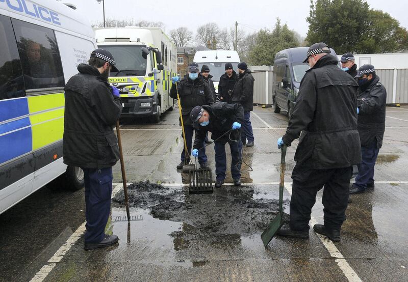 Police officers search drains at a car park in Sandwich, southern England, Tuesday March 16, 2021, believed to be connected to the investigation into the nearby discovery of the body of 33-year old Sarah Everard.  Sarah Everard has become the subject of public demonstrations about women's safety, after she went missing while walking home on March 3, and a serving police officer stands charged with her kidnap and murder. (Gareth Fuller/PA via AP)