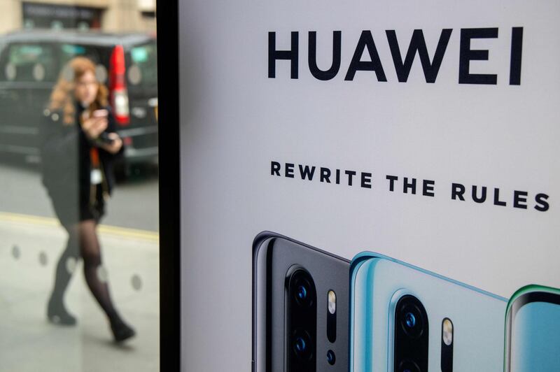 (FILES) In this file photo taken on April 29, 2019 A pedestrian walks past a Huawei product stand at an EE telecommunications shop in central London on April 29, 2019. Britain is expected to announce next week whether to allow China's Huawei to develop its 5G network, an official said on January 24, 2020, indicating it will agree to limited access despite intense opposition from Washington. / AFP / Tolga Akmen
