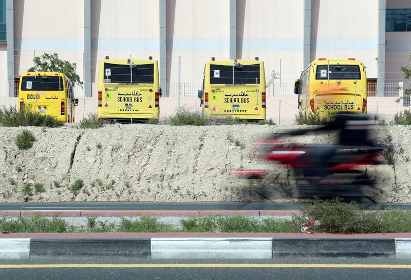 Dubai, United Arab Emirates - Reporter: N/A: School busses sit idle while a delivery scooter zooms passed on Hessa Street as Dubai goes into lockdown for 2 weeks due to the corona virus. Wednesday, April 8th, 2020. Dubai. Chris Whiteoak / The National