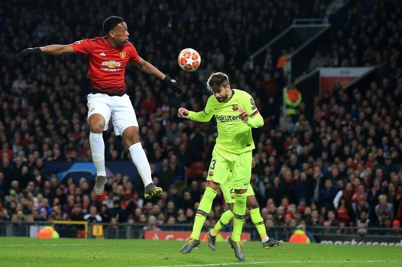 Manchester United's Anthony Martial, left, and Barcelona's Gerard Pique jump for the ball. AP Photo