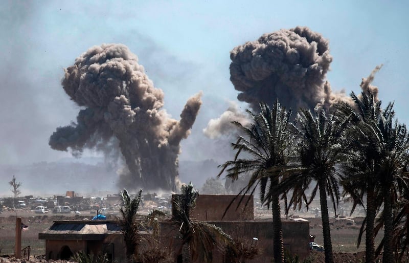 Heavy smoke rises above the Islamic State (IS) group's last remaining position in the village of Baghouz during battles with the Syrian Democratic Forces (SDF), in the countryside of the eastern Syrian province of Deir Ezzor on March 18, 2019. An air strike pounds a demolished bridge in eastern Syria, sending armed men scampering to hide among the cars and tents of the Islamic State group's smouldering last redoubt. / AFP / Delil SOULEIMAN
