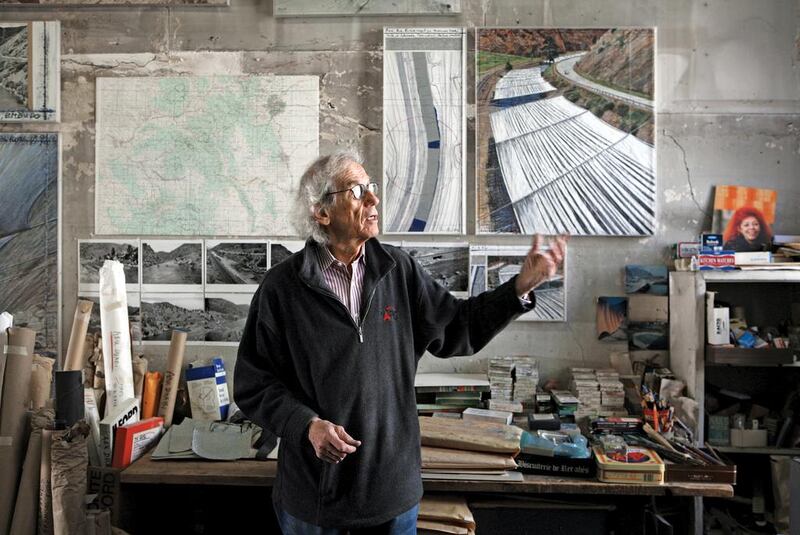 Christo in his studio with a preparatory collage for Over The River. Courtesy Christo