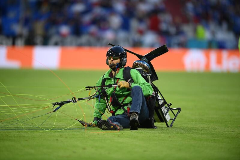 The Greenpeace activist sits on the pitch after landing. EPA