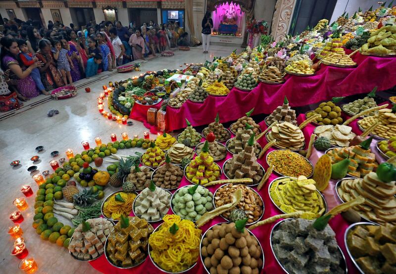 Devotees pray next to sweets and fruits that are kept as offerings by the devotees as part of a ritual to mark Annakut festival during Diwali in Ahmedabad, India. Reuters