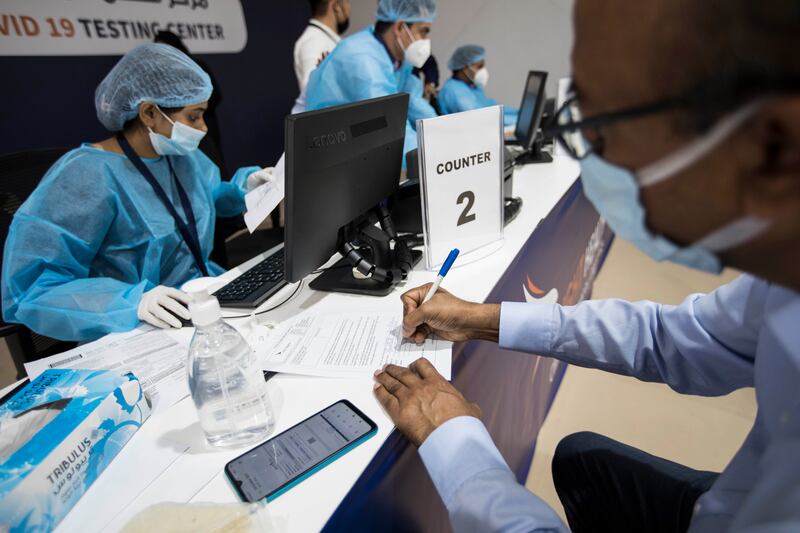 A man fills in his details before having a PCR test.