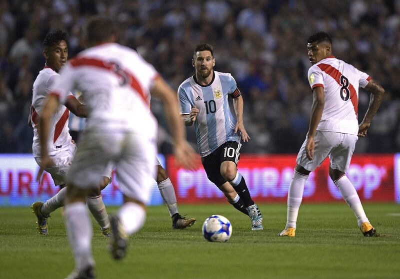 Argentina's Lionel Messi (C) drives the ball during the 2018 World Cup football qualifier match against Peru in Buenos Aires on October 5, 2017. / AFP PHOTO / Juan MABROMATA