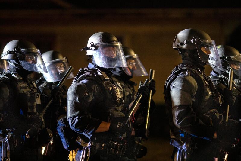 Portland police take control of the streets after making arrests on the scene of the nightly protests at a Portland police precinct in Portland, Ore. Oregon State Police will return to Portland to help local authorities after the fatal shooting of a man.  AP