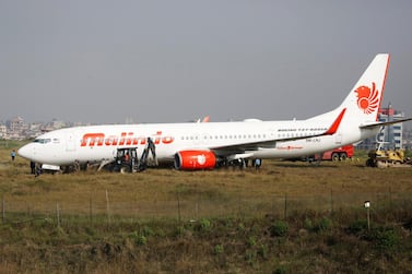 Officials check an aircraft belonging to Malindo Airlines that skidded off the runway during take off on the night of April 19, 2018 at Tribhuvan International Airport in Kathmandu, Nepal. Navesh Chitrakar / Reuters
