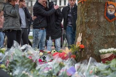 People cry after laying flowers at a makeshift memorial site for the victims of a shooting incident in a tram in Utrecht, Netherlands. AP