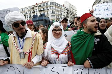 Students wearing traditional clothes hold banners and shout slogans during a protest calling on President Abdelaziz Bouteflika to quit, in Algiers, Algeria March 26, 2019. Reuters