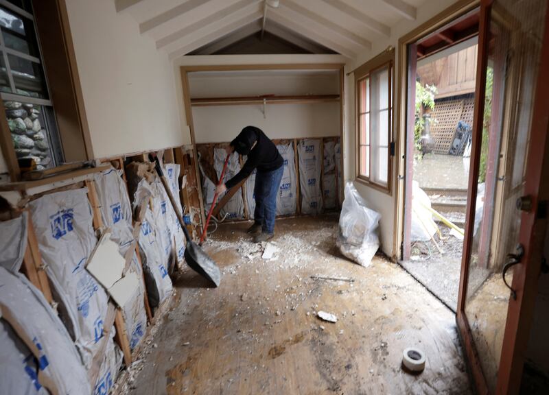 A man cleans up a flood-hit house in Carmel Valley. Reuters