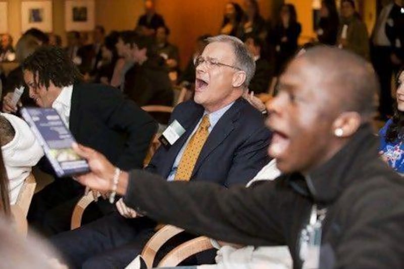 Byron Pollitt, centre, the chief financial officer for Visa, reacts while watching a Financial Soccer video game at the Financial Literacy & Education Summit in Chicago, which was co-hosted by the Federal Reserve Bank of Chicago and Visa. Peter Wynn Thompson for The National (w)