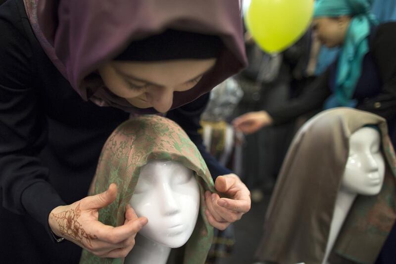 A Russian Muslim woman ties an Islamic head scarf onto the head of a mannequin during a celebration of the World Hijab Day in a store in Moscow (AP Photo/Alexander Zemlianichenko)