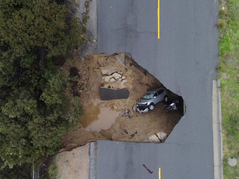 People had to be rescued after two vehicles fell into a sinkhole in Chatsworth as storms continue to ravage California.  Reuters