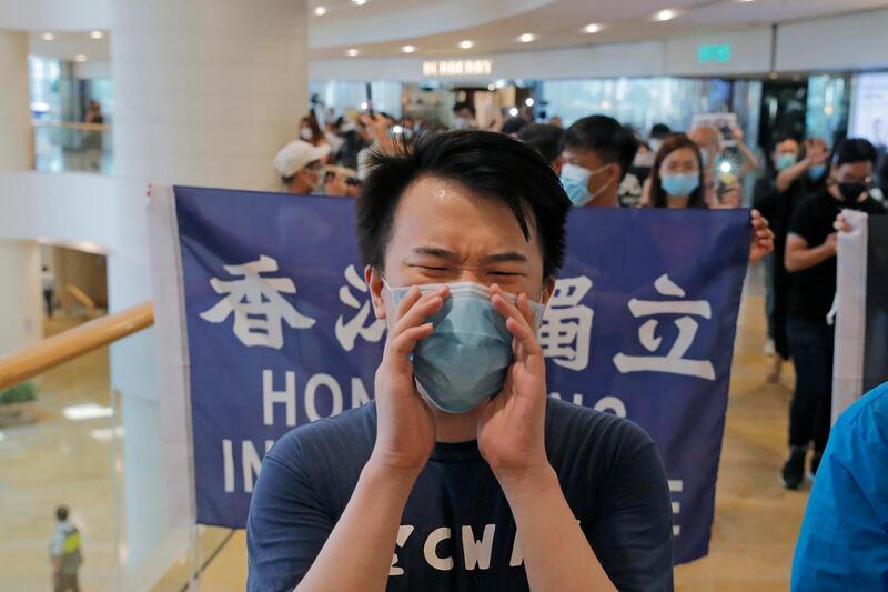 Protesters hold flags and shout slogans in a shopping mall during a protest in Hong Kong. Protesters in Hong Kong managed to make the government withdraw extradition legislation last year, but now they're getting a more dreaded national security law and the message from Beijing is that protest is futile. AP Photo