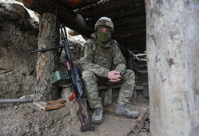 Ukrainian soldiers sits in a fighting position on the line of separation from pro-Russian rebels near Debaltsevo, Donetsk region, Ukraine. AP