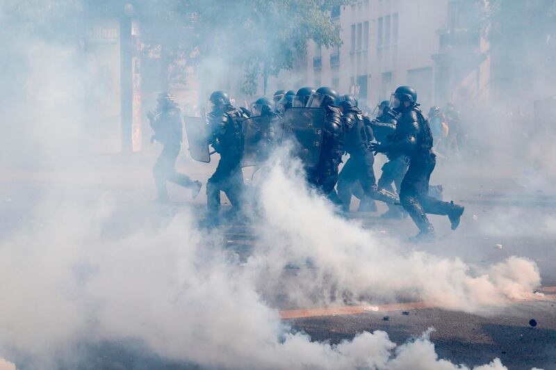 French gendarmes run through smoke of tear gas, during a May Day demonstration when more than 7,400 police and gendarmes were deployed across Paris. AFP