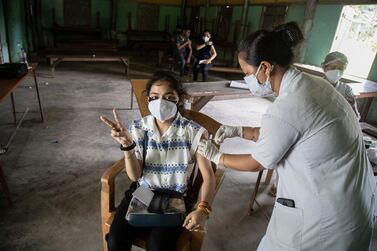 An Indian woman getting vaccinated with a dose of Covaxin against the coronavirus gestures to camera in Gauhati, Assam, India. AP 