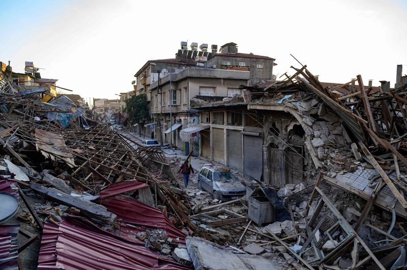 A man walks past the rubble of a destroyed building. AFP