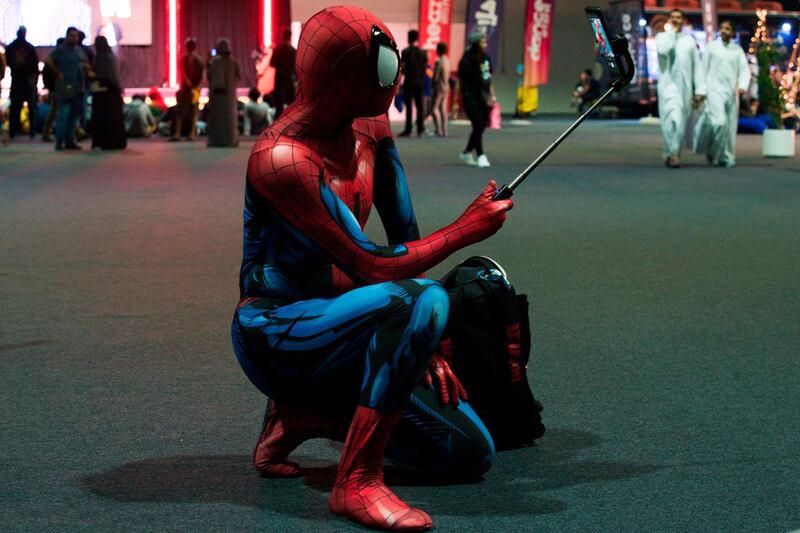 A man dressed as Spiderman pauses for a selfie. AP Photo