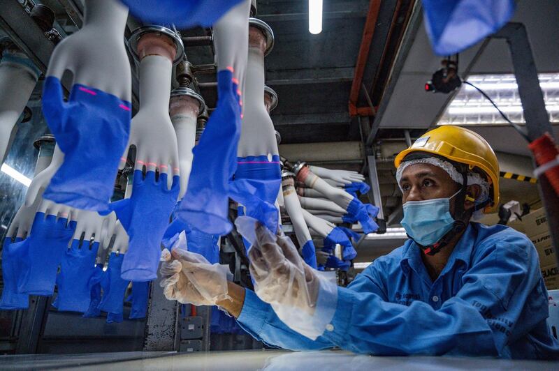 A worker inspects disposable gloves at the Top Glove factory in Shah Alam on the outskirts of Kuala Lumpur.  AFP