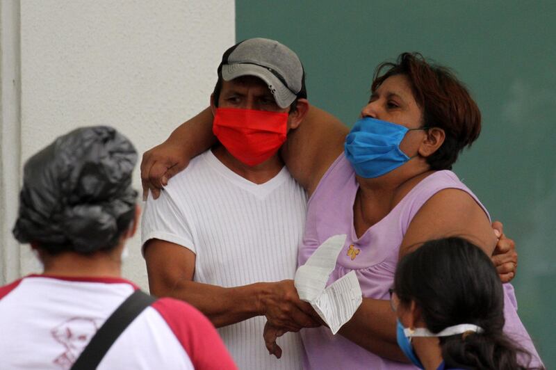 A man helps a sick woman enter a hospital in Guayaquil, Ecuador.  AFP