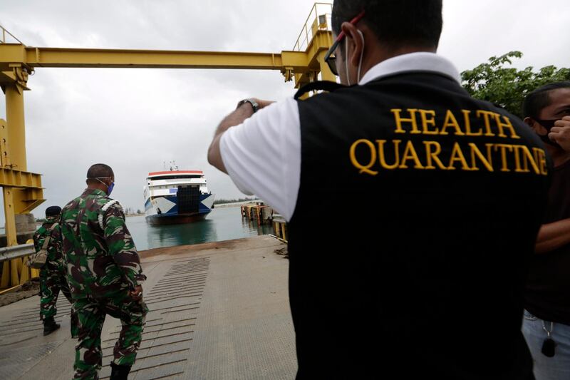 An Indonesia Health Quarantine Officer waits for the the last ship arriving at Ulee Lhuee port in Banda Aceh, Indonesia. The Aceh government has stopped all public  transport operations to avoid the annual Eid al-Fitr mass exodus amid the coronavirus pandemic. Eid al-Fitr marks the end of the Muslim's holy month of Ramadan.  EPA