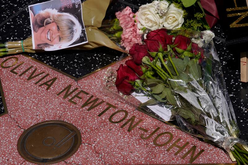 Flowers adorn Olivia Newton-John's Hollywood Walk of Fame star in Los Angeles, Monday, Aug.  8, 2022.  Newton-John, the Grammy-winning superstar who reigned on pop, country, adult contemporary and dance charts with such hits as "Physical" and "You're the One That I Want" has died.  She was 73.  (AP Photo / Damian Dovarganes)