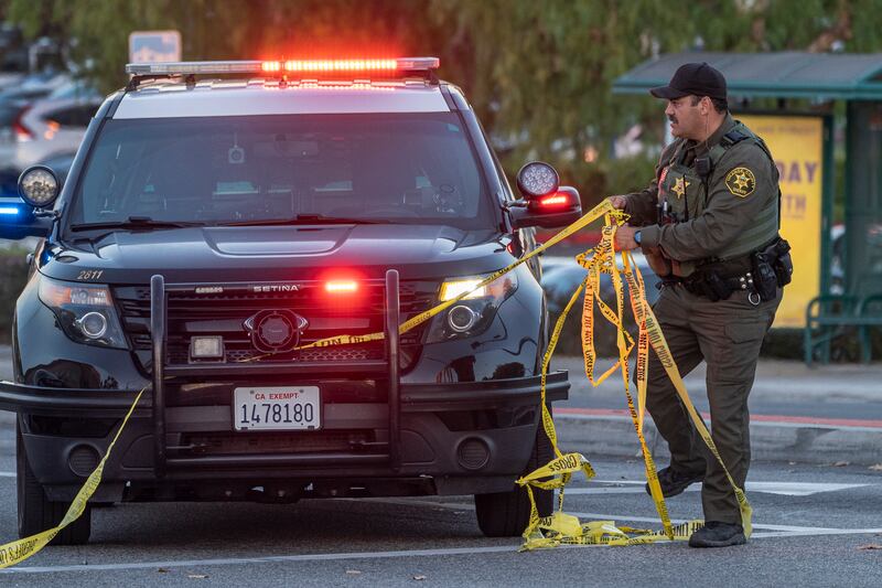 A police officer removes yellow tape from the crime scene. AP