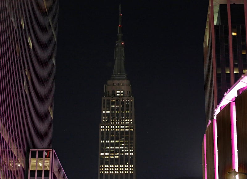 The Empire State Building lights, normally lit in colours, are dimmed on Monday, October 2, 2017, in New York, in sympathy for the victims of the mass shooting in Las Vegas. Kathy Willens / AP Photo