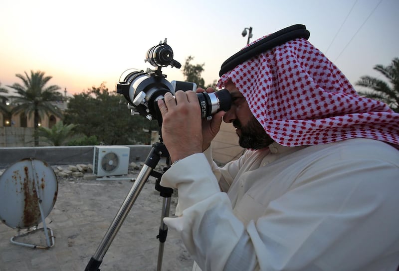 A Sunni Muslim cleric uses a telescope to gaze while searching for the crescent moon, which if sighted would mark the beginning of the Muslim holy month of Ramadan, at the Abu Al Hanifa Al Numan mosque in the Adhamiya district of of Iraq's capital Baghdad.  AFP
