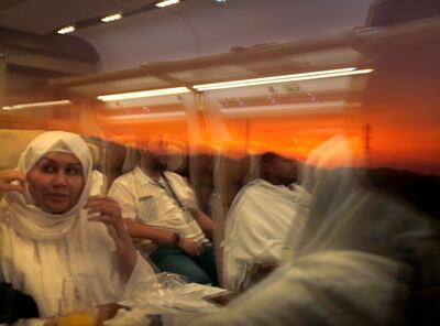 Pilgrims on their way to Mecca are reflected on the window of the Haramain High-Speed Railway train in the holy city of Medina, Saudi Arabia, Thursday, Aug. 8, 2019. Hundreds of thousands of Muslims have arrived in the kingdom to participate in the annual hajj pilgrimage, which starts Friday, a ritual required of all able-bodied Muslims at least once in their life. (AP Photo/Amr Nabil)