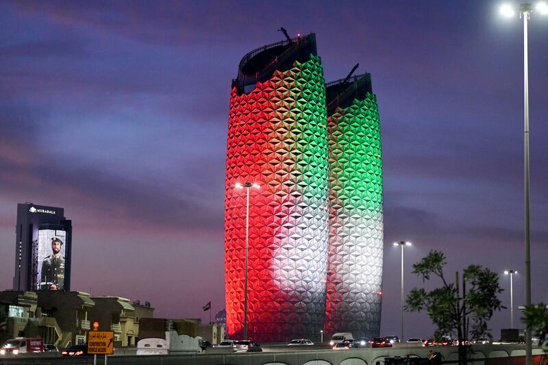 Al Bahr Towers illuminated for National Day, while Mubadala tower, right, marks Commemoration Day, in Abu Dhabi. Khushnum Bhandari / The National