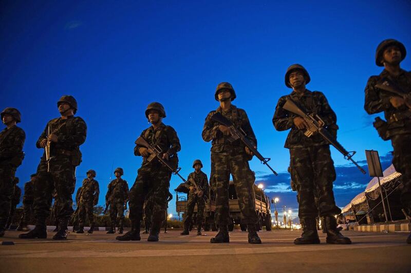 Thai army soldiers stand guard at the main entrance of the pro-government ''Red Shirts'' rally site after they shut it down and cleared protesters from the site, after Thailand's army chief announced that the armed forces were seizing power, on the outskirts of Bangkok on May 22, 2014. Nicolas Asfouri/AFP Photo