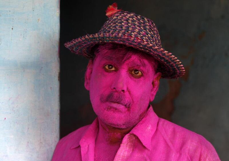 An Indian man with his face smeared with colours to celebrate Holi. The holiday marks the beginning of spring and the triumph of good over evil. Rajesh Kumar Singh / AP Photo