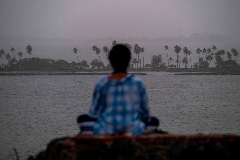 A woman meditates during the hazy conditions in Puerto Rico. AFP