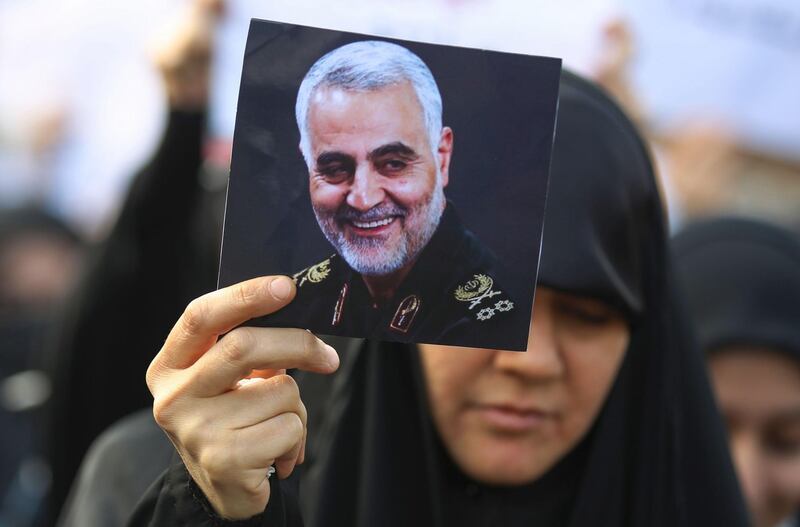 An Iraqi woman attends the funeral of Iranian military commander Qasem Soleimani (portrait), Iraqi paramilitary chief Abu Mahdi al-Muhandis and eight others in Baghdad's district of al-Jadriya, in Baghdad's high-security Green Zone, on January 4, 2020. Thousands of Iraqis chanting "Death to America" joined the funeral procession for Iranian commander Qassem Soleimani and Iraqi paramilitary chief Abu Mahdi al-Muhandis, both killed in a US air strike. The cortege set off around Kadhimiya, a Shiite pilgrimage district of Baghdad, before heading to the Green Zone government and diplomatic district where a state funeral was to be held attended by top dignitaries. In all, 10 people -- five Iraqis and five Iranians -- were killed in Friday morning's US strike on their motorcade just outside Baghdad airport. / AFP / AHMAD AL-RUBAYE

