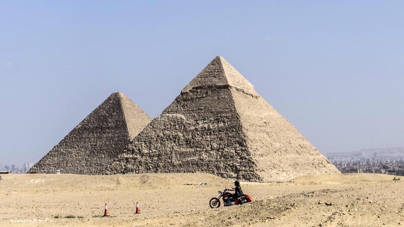 People ride their motorcycles during an organised tour at the Giza Pyramids in Cairo, Egypt. AFP