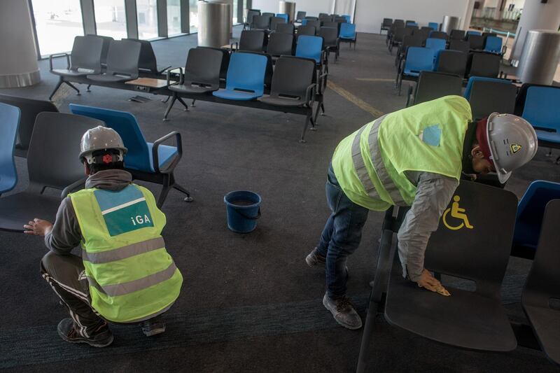 Airport employees clean chairs in the completed hall "B" section. Getty Images