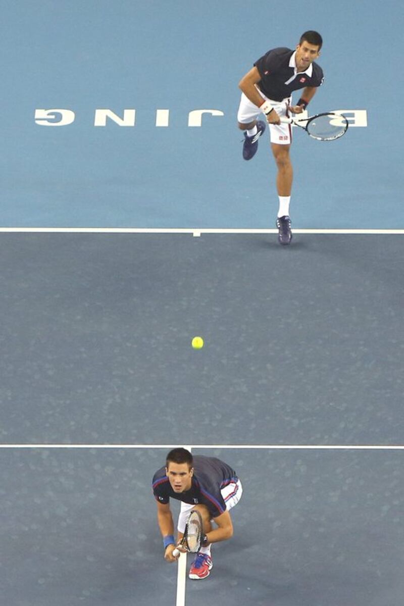 Novak Djokovic serves during his doubles match on Tuesday in Beijing with brother Djordje, their first time pairing for a match. Emmanuel Wong / Getty Images