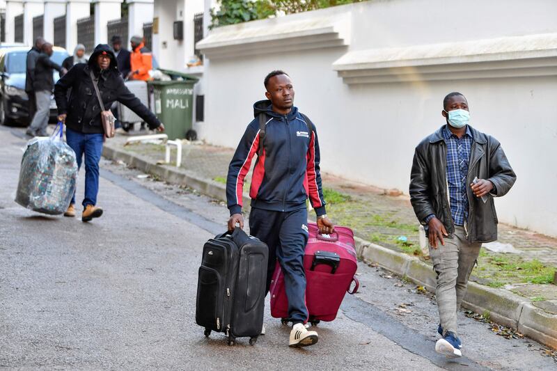 Sub-Saharan migrants take their belongings as they head to a repatriation flight, leaving Tunis to their countries of origin on March 4. AFP