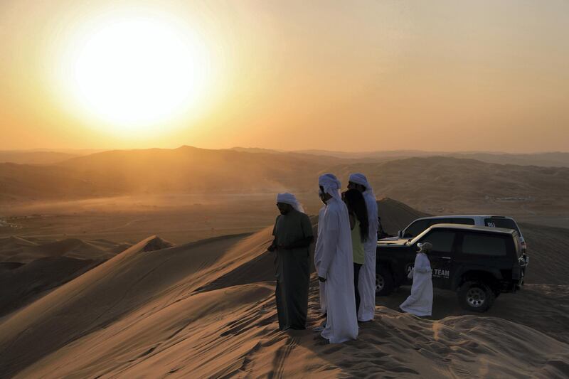 Abu Dhabi, United Arab Emirates, January 2, 2020.  4X4 goers watch different desert 4X4 mobiles go up the Al Al Moreeb Dune at the 2020 Liwa Festival.
Victor Besa / The National
Section:  NA
Reporter:  Haneen Dajani
