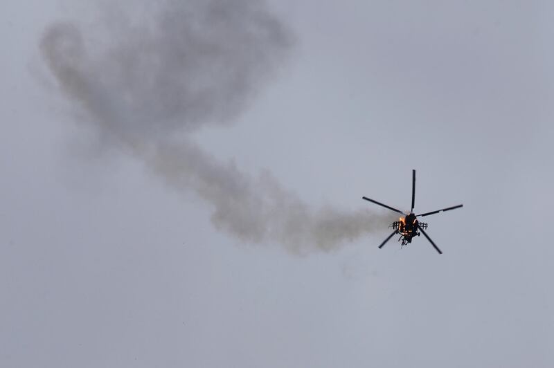 A Syrian government helicopter bursts in flames after it was hit by a missile in Idlib province on February 11, 2020. AP