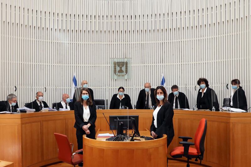 A panel of 11 judges of the Israeli Supreme Court wear face masks as they address a discussion on a petition asking whether Israeli Prime Minister Benjamin Netanyahu can form a government legally and publicly when indictments are filed against him on a charges of fraud, bribery, and breach of trust, at the Israeli Supreme Court in Jerusalem May 4, 2020. Abir Sultan/Pool via REUTERS