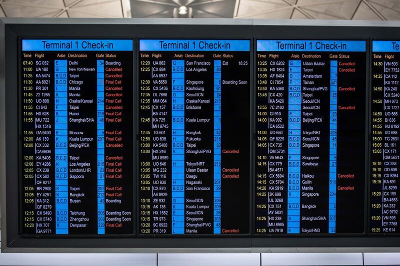 Flight information is displayed on screens at Hong Kong International Airport in Hong Kong, China, on Thursday, Feb. 6, 2020. Cathay asked employees to take three weeks of unpaid leave as the Hong Kong airline is cutting capacity because of the coronavirus outbreak. Photographer: Ivan Abreu/Bloomberg
