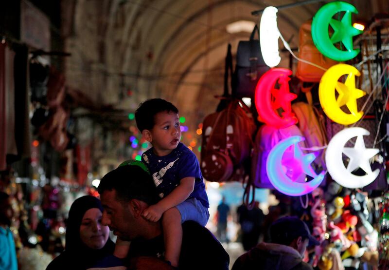 Palestinians walk past shops decorated in Jerusalem's old city. AFP