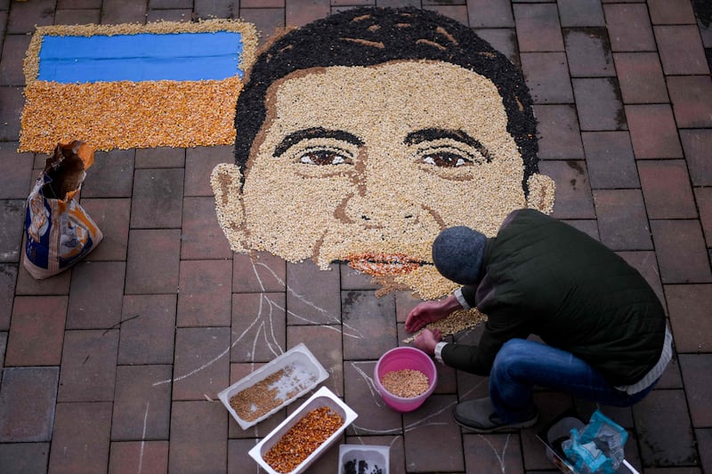 Kosovo artist Alkent Pozhegu works on the final touches of Ukrainian President Volodymyr Zelenskyy's portrait made with grains and seeds, in Gjakova, southwestern Kosovo. AFP