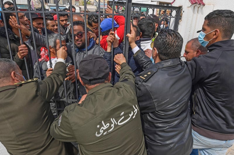 Security forces close the gate as impoverished Tunisian citizens protest against the general confinement and to claim the financial aid promised by the government.  AFP