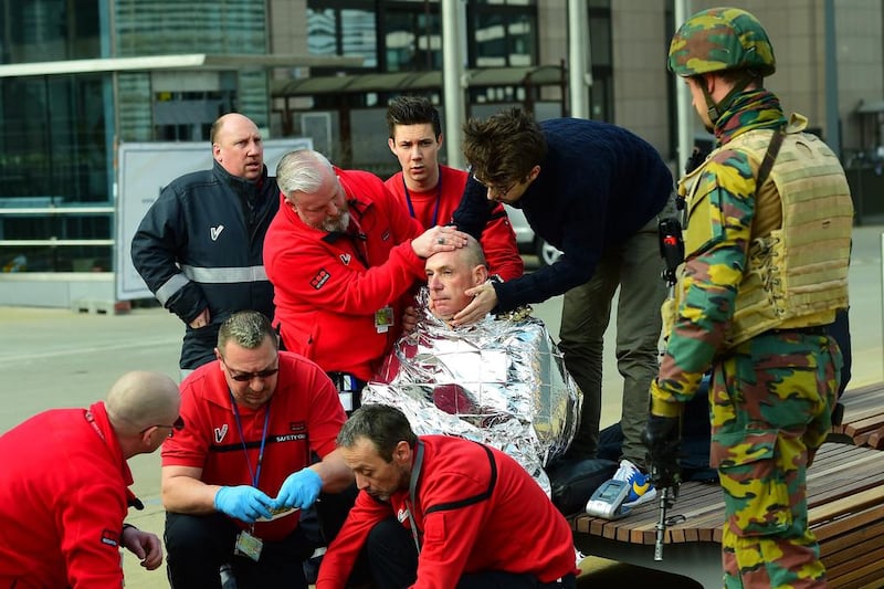 A victim receives first aid by rescuers, near Maalbeek metro station in Brussels, after a blast at this station near the EU institutions caused deaths and injuries.  Emmanuel Dunand / AFP